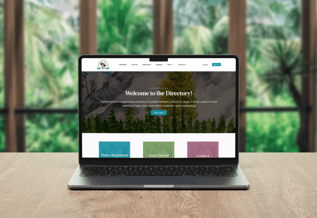 A laptop displaying a website titled 'Welcome to the Directory!' with options for finding herbalists, studying herbalism, and locating institutions, set against a blurred green natural background.